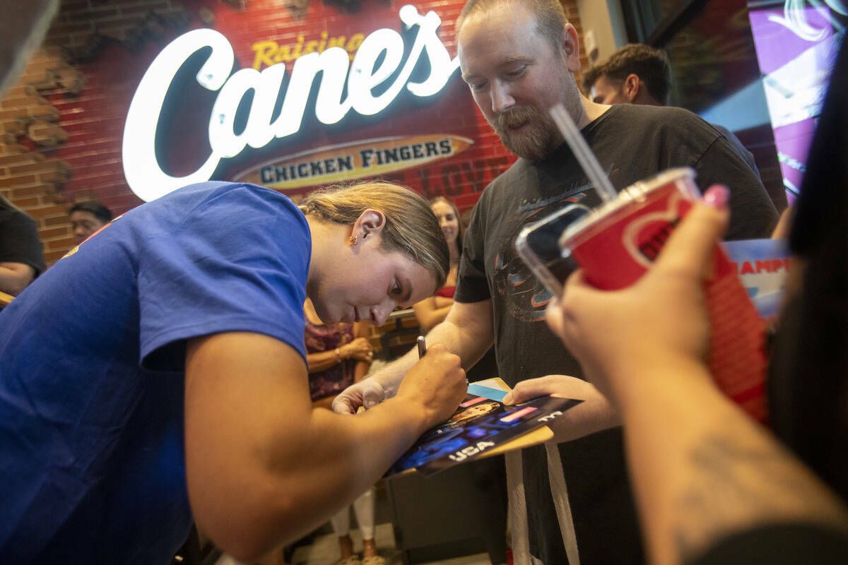 La medallista olímpica Katie Grimes firma fotografías durante un ‘turno’ promocional de b ...