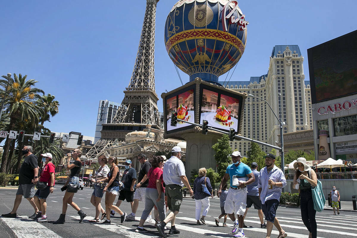 Turistas cruzan Las Vegas Boulevard cerca del hotel-casino Paris, el viernes 3 de julio de 2020 ...