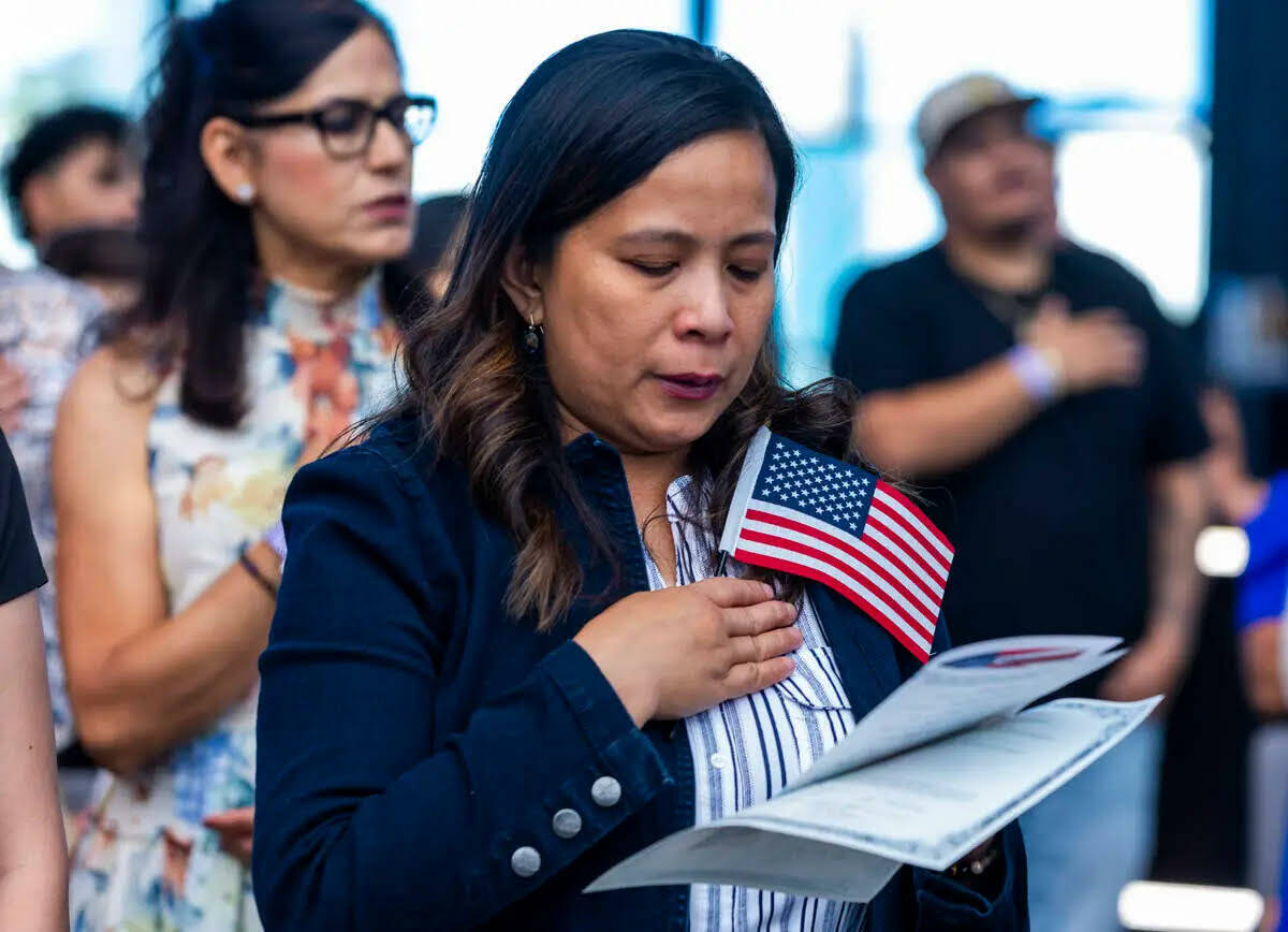 La aspirante Rosalyn Tuggle se pone de pie con otros para el Juramento de Lealtad durante una c ...