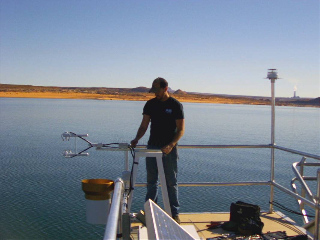 Un investigador ajusta el equipo durante la instalación de una estación de evaporación flota ...