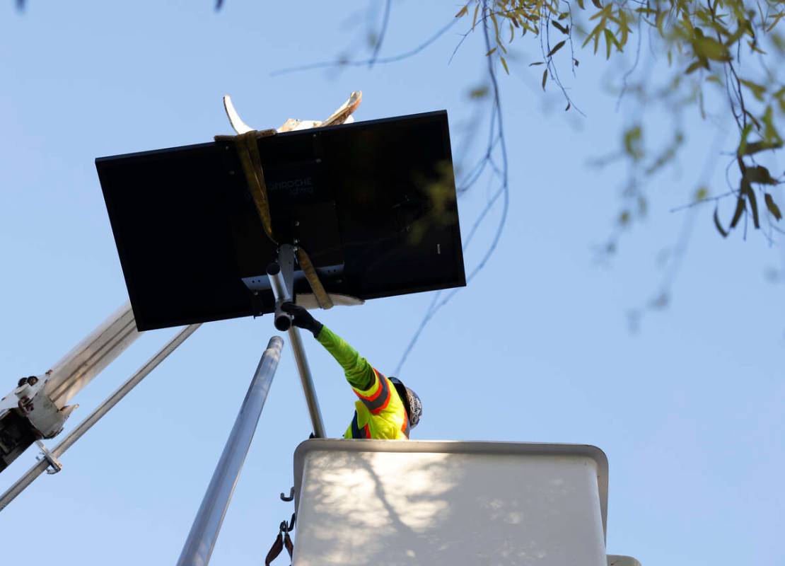 Un trabajador del Departamento de Obras Públicas del Condado Clark instala una de las 12 nueva ...