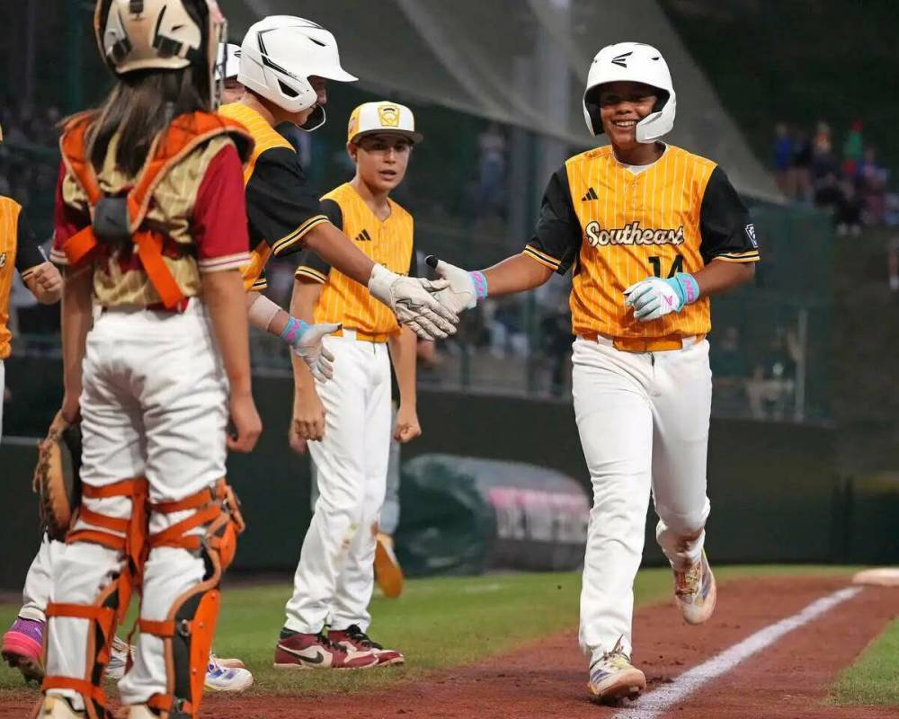 James Feliciano, de Lake Mary, Fla., es saludado por sus compañeros de equipo después de bate ...