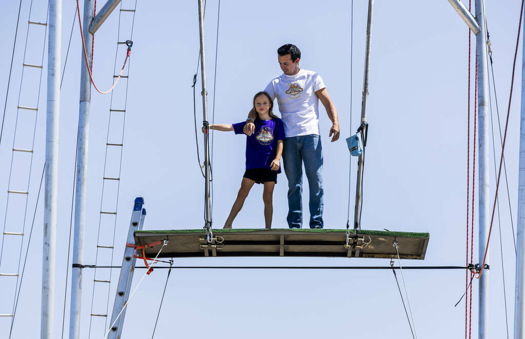 Renato Fernandes con su hija Katalina en lo alto de una plataforma en el trapecio de su patio t ...