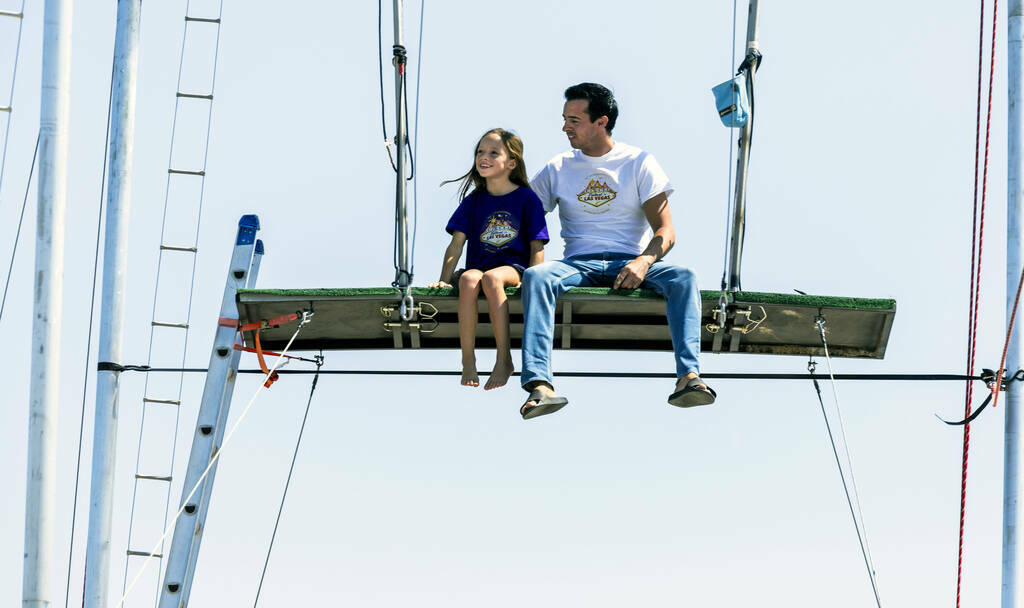 Renato Fernandes con su hija Katalina sentados en lo alto de una plataforma en el trapecio de s ...