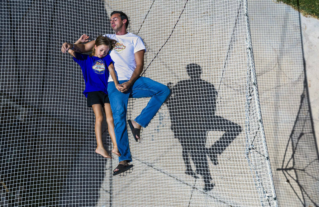 Renato Fernandes y su hija Katalina se relajan encima de una red en el trapecio de su patio tre ...