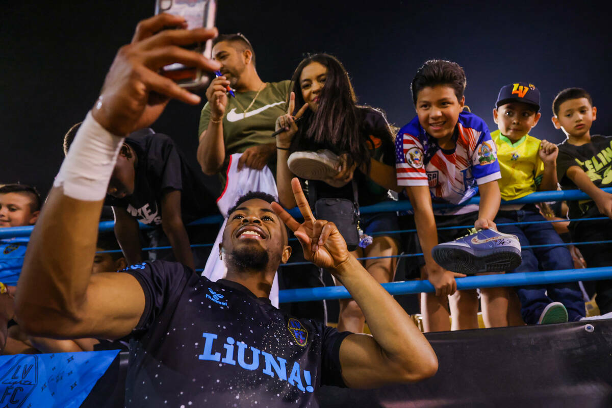 El delantero de Lights FC Khori Bennett posa para fotografías con los aficionados tras un part ...