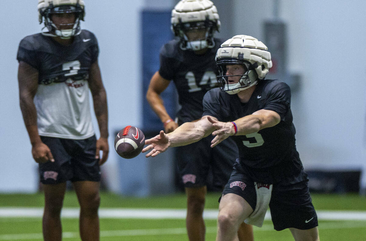 El quarterback de la UNLV Matthew Sluka (3) lanza el balón a un running back durante un entren ...