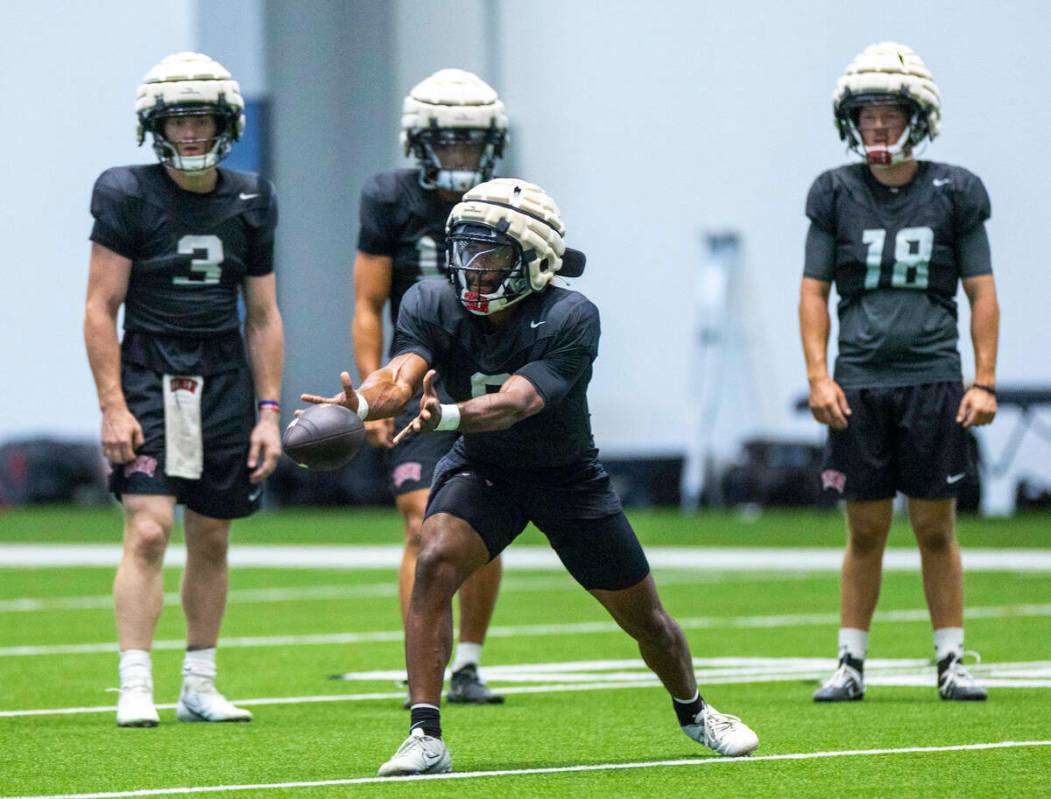 El quarterback de la UNLV Hajj-Malik Williams (6) lanza el balón a un running back durante un ...