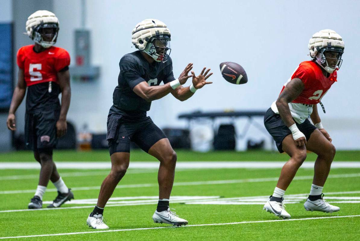 El quarterback de la UNLV Hajj-Malik Williams (6) recibe el balón durante una práctica de fú ...