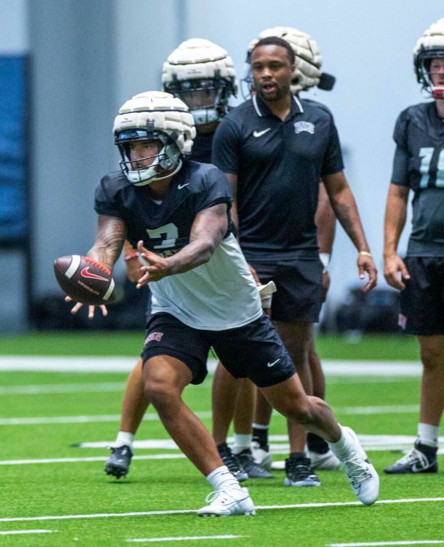 El quarterback de la UNLV Cameron Friel (7) lanza el balón a un running back durante un entren ...