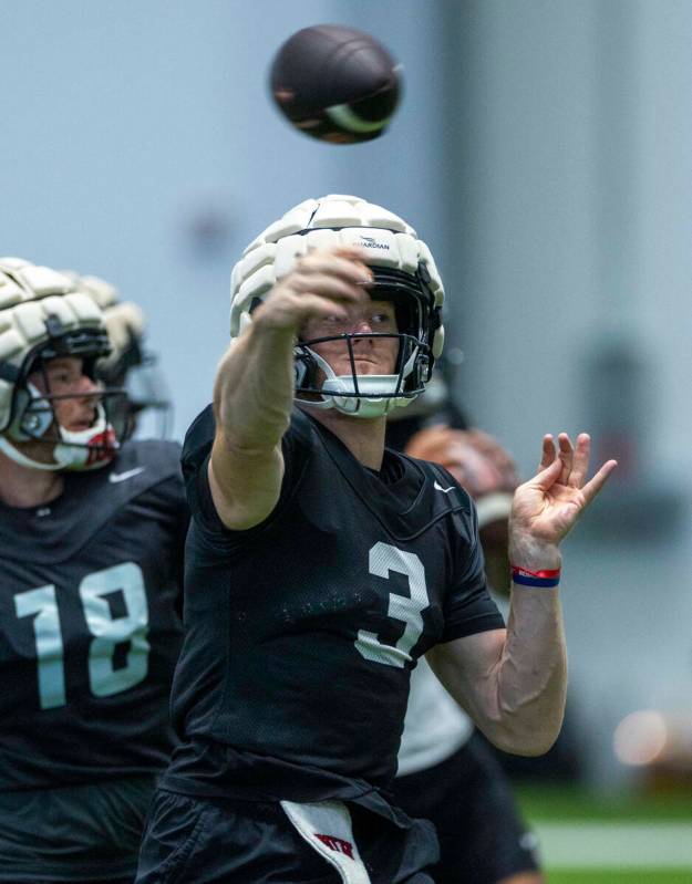 El quarterback de la UNLV Matthew Sluka (3) lanza un pase a un receptor durante un entrenamient ...