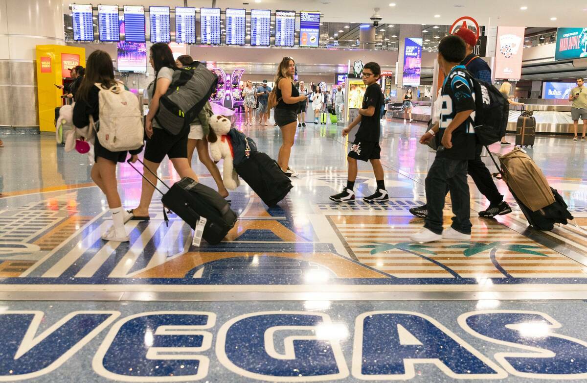 Pasajeros que llegan se dirigen a la zona de reclamo de equipaje en la Terminal 1 del Aeropuert ...