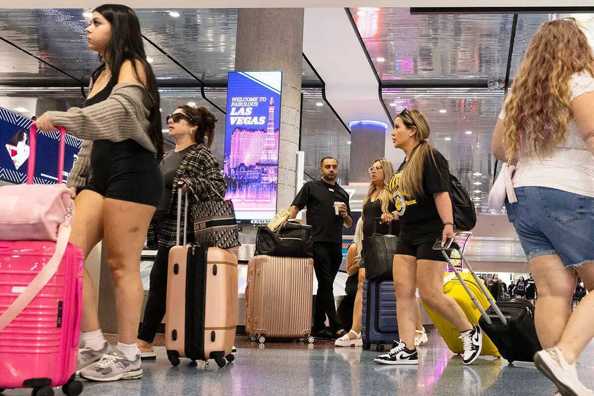 Los pasajeros que llegan se dirigen a la zona de recolección de equipaje en la Terminal 1 del ...