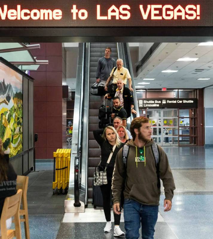 Los pasajeros que llegan se dirigen a la zona de recolección de equipaje en la Terminal 1 del ...