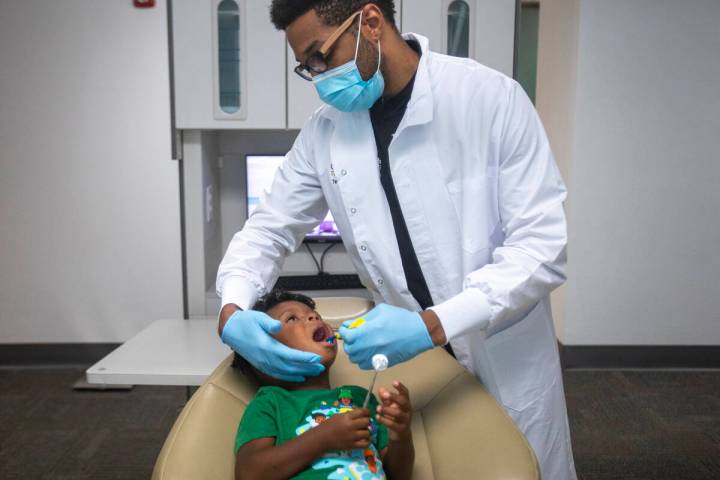 El doctor Terry Meads, de la odontología pediátrica Changing Smiles, le limpia los dientes a ...