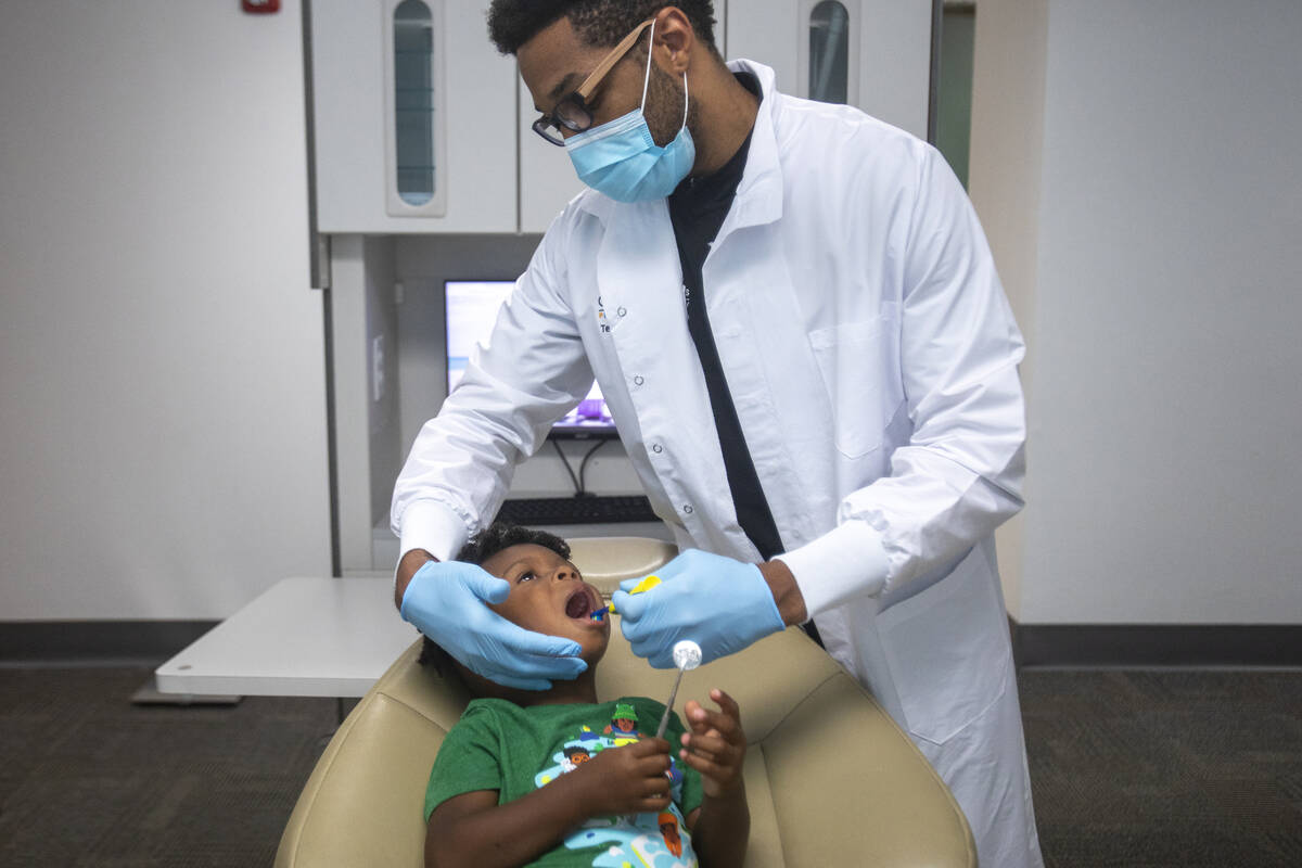 El doctor Terry Meads, de la odontología pediátrica Changing Smiles, le limpia los dientes a ...