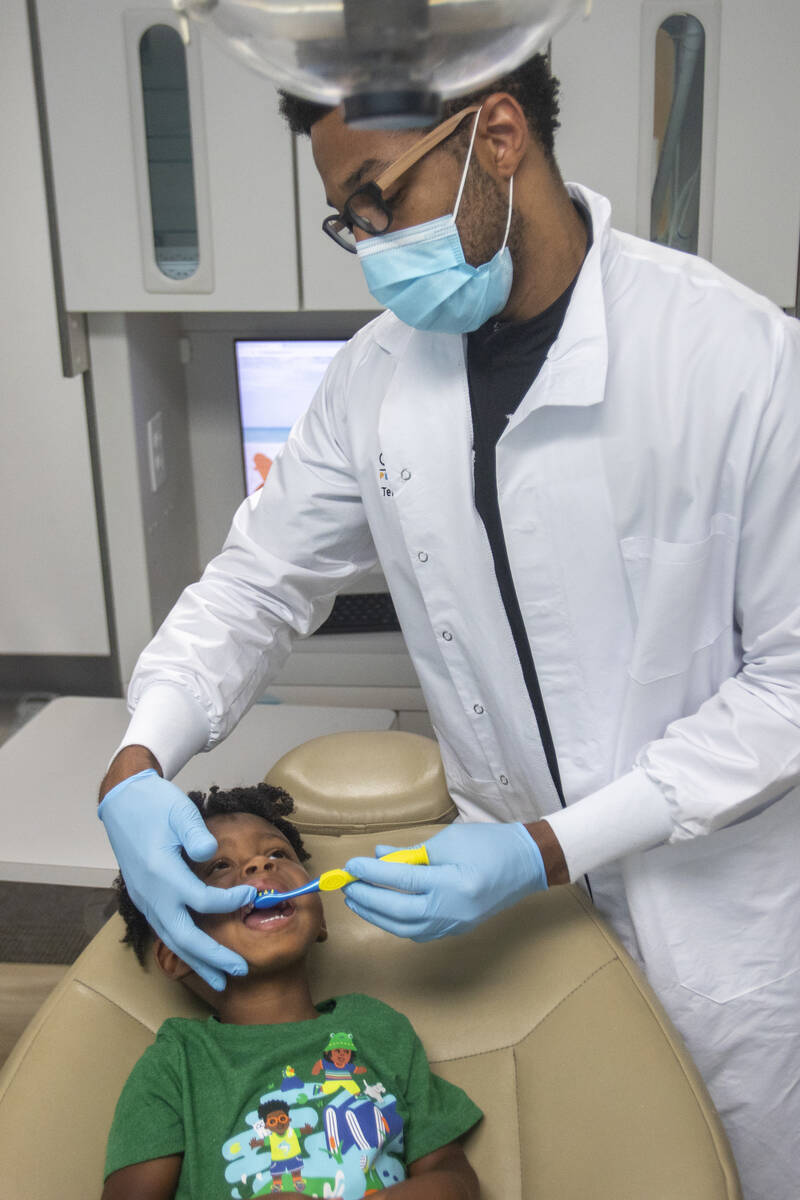 El doctor Terry Meads, de la odontología pediátrica Changing Smiles, le limpia los dientes a ...