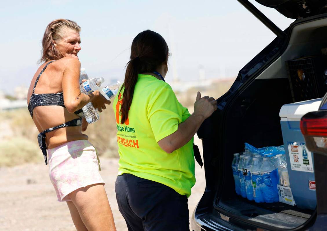 Jaqualyne Peeples, trabajadora de Help of Southern Nevada, entrega agua a Tamara Christian, qui ...