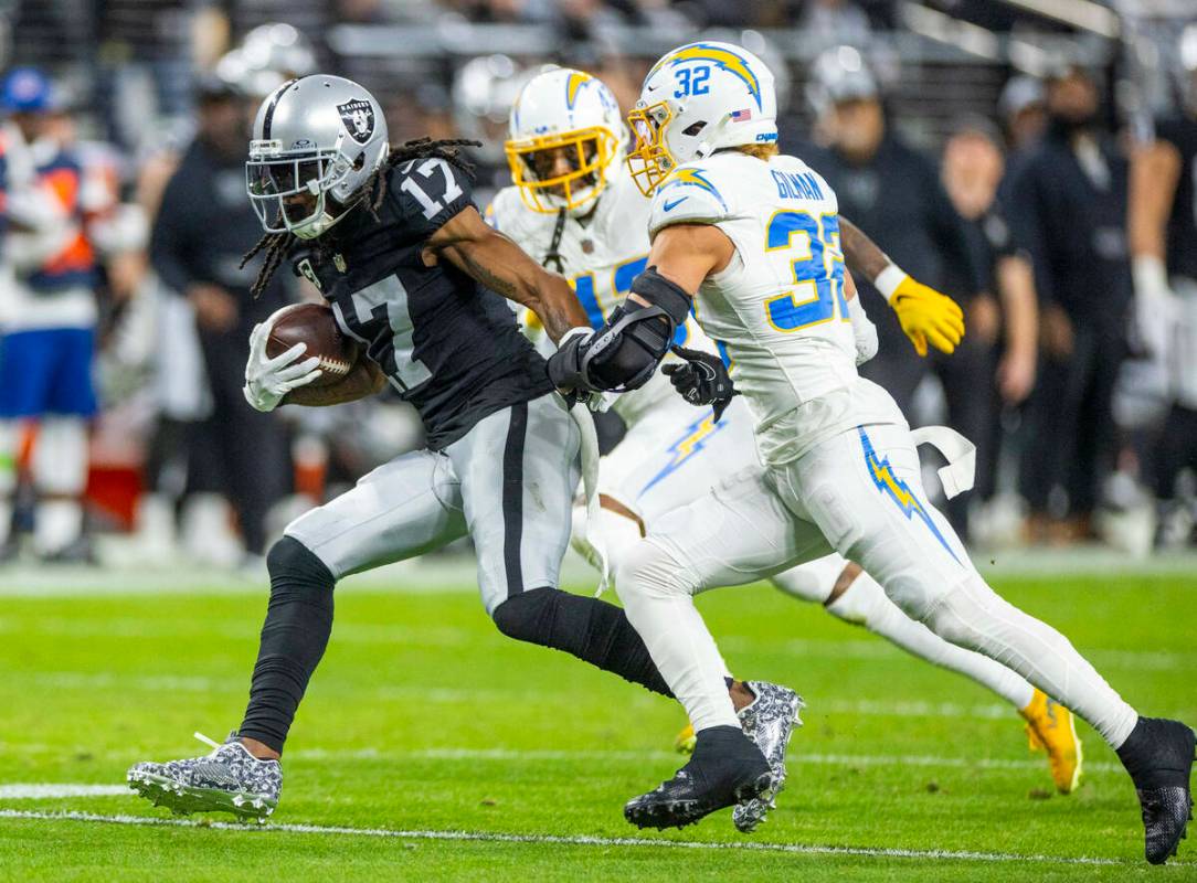 El wide receiver de los Raiders Davante Adams (17) corre tras una captura mientras el safety de ...