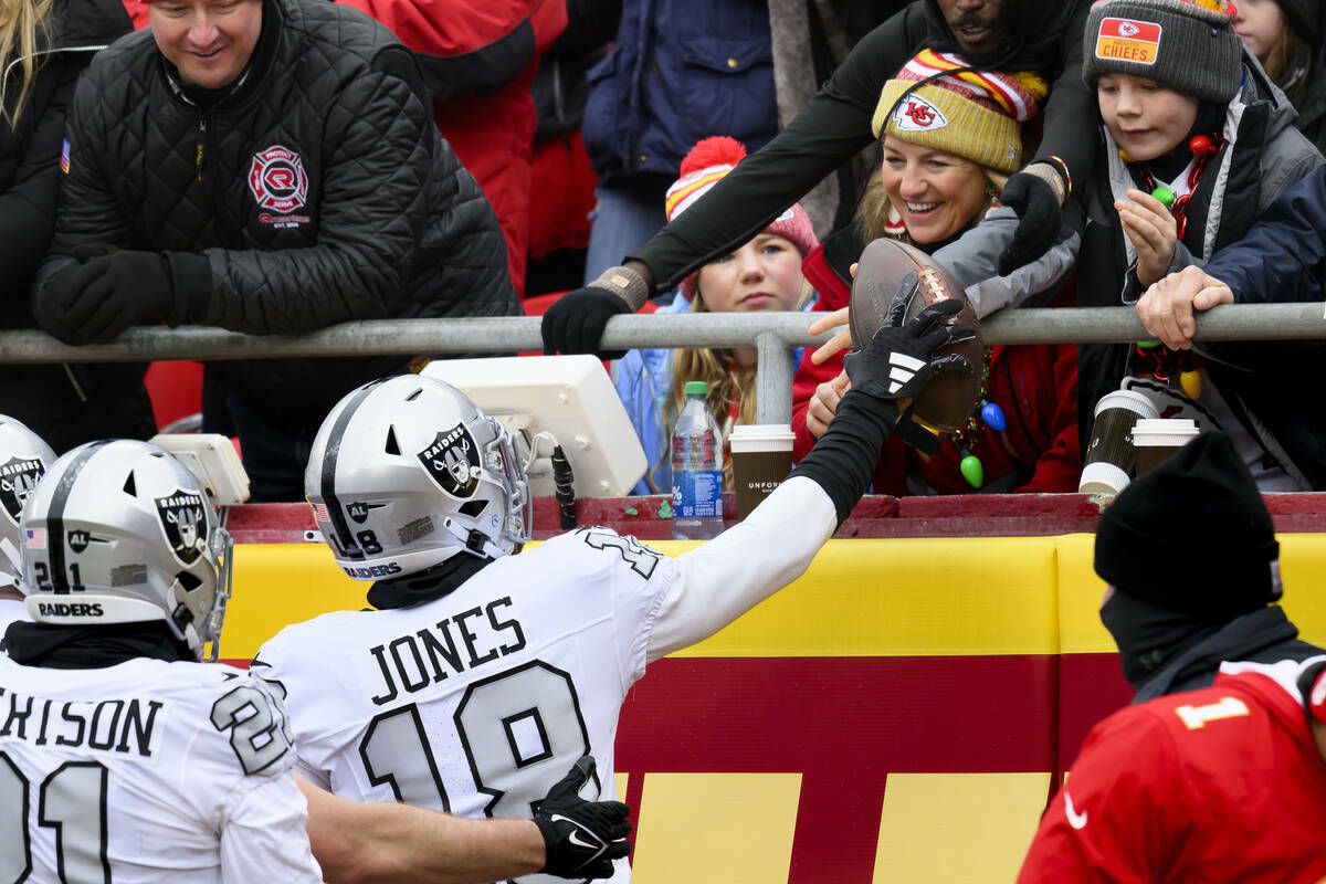 El cornerback de los Raiders de Las Vegas Jack Jones (18) entrega el balón a los fans tras ano ...