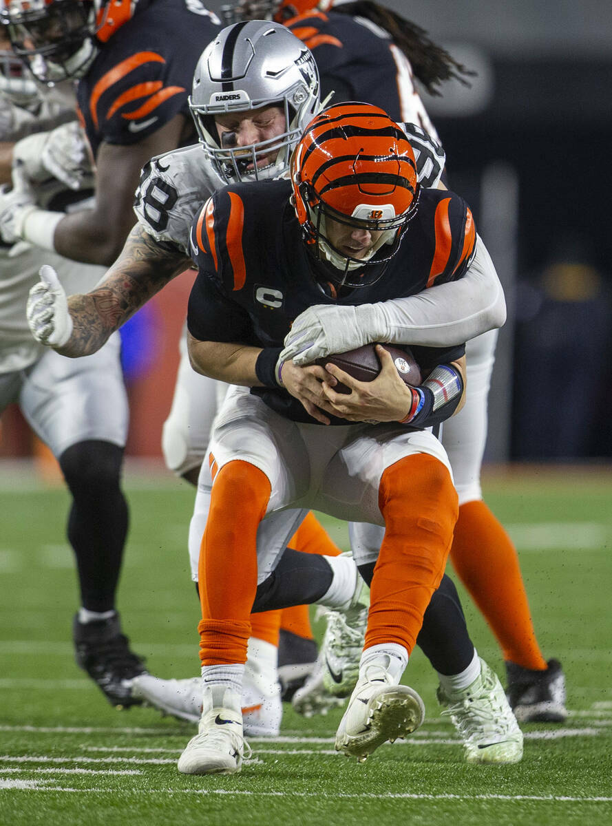 El defensive end de los Raiders Maxx Crosby (98) atrapa al quarterback de los Cincinnati Bengal ...