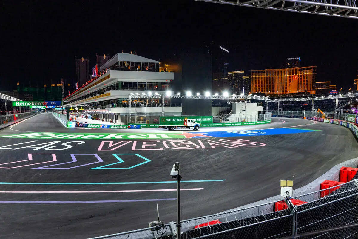 Una grúa sale del edificio de pits para recoger el auto de Carlos Sainz, de Ferrari, después ...