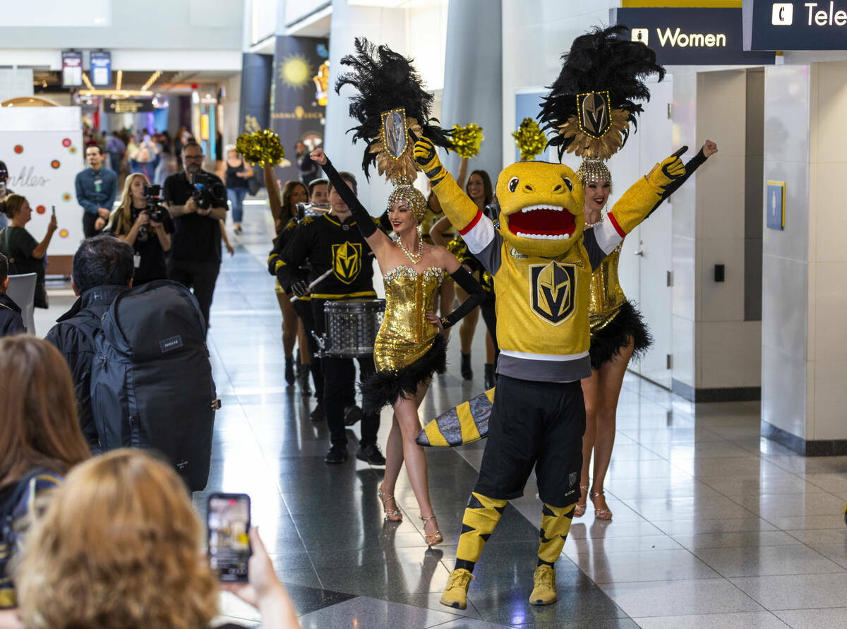 La mascota de los Golden Knights, Chance, encabeza una procesión de coristas, los Drumbeats y ...