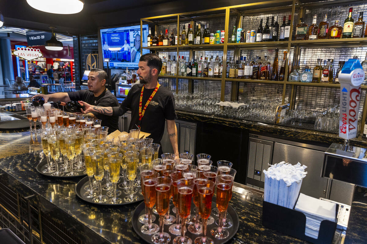 Cantineros sirven cocteles para los invitados durante la celebración de la gran inauguración ...