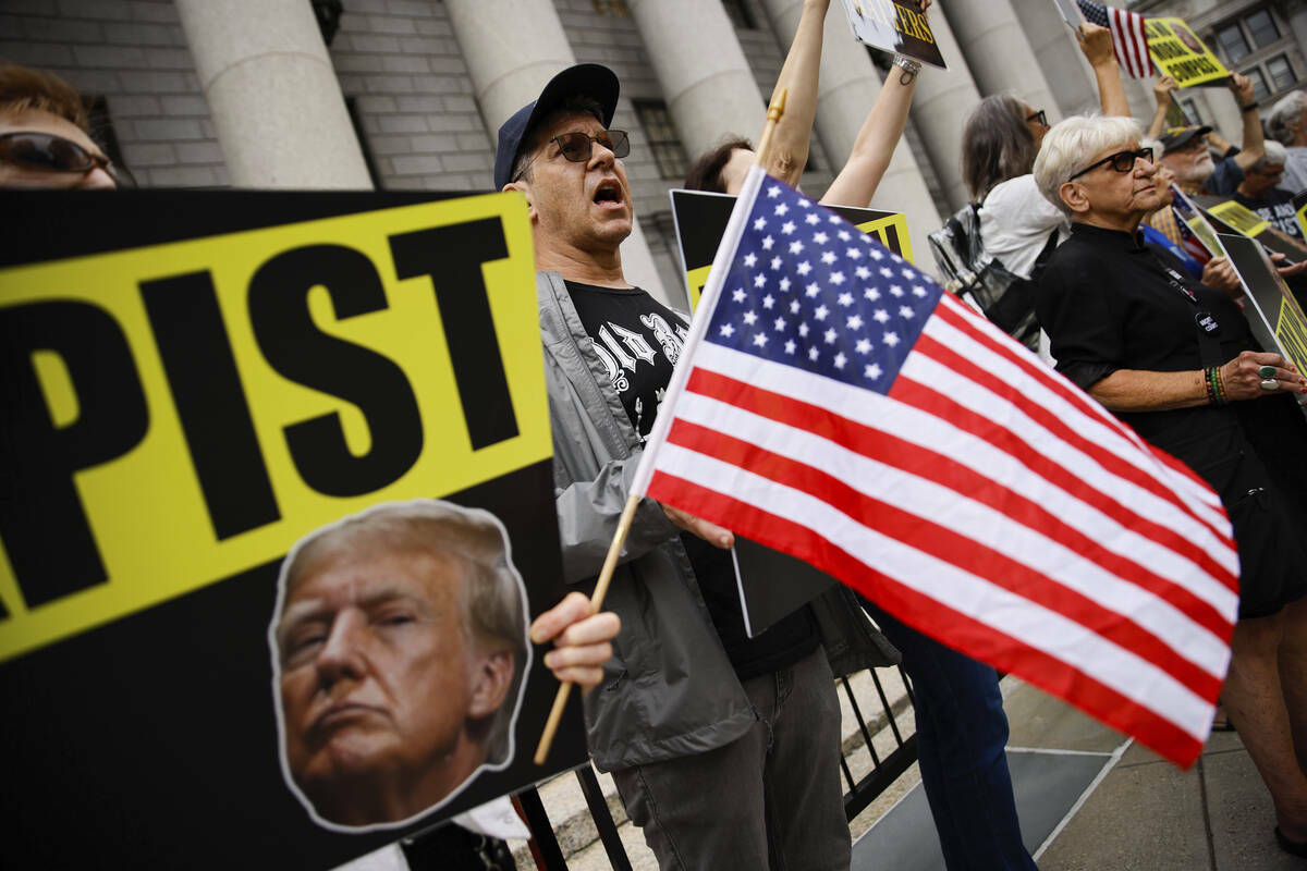 Personas protestan contra el expresidente Donald Trump antes de su llegada a la Tribunal Federa ...