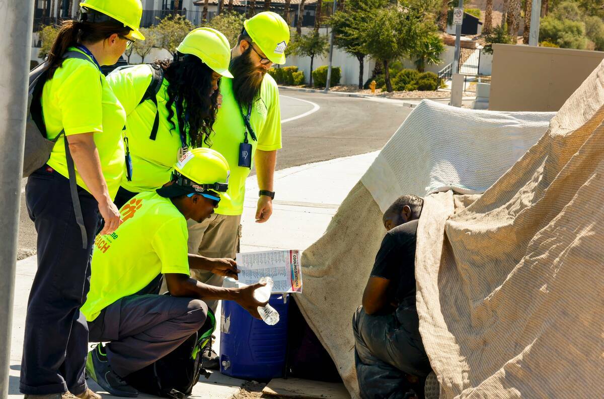 Trabajadores de Help of Southern Nevada hablan con Darryl Walker, a la derecha, una persona sin ...