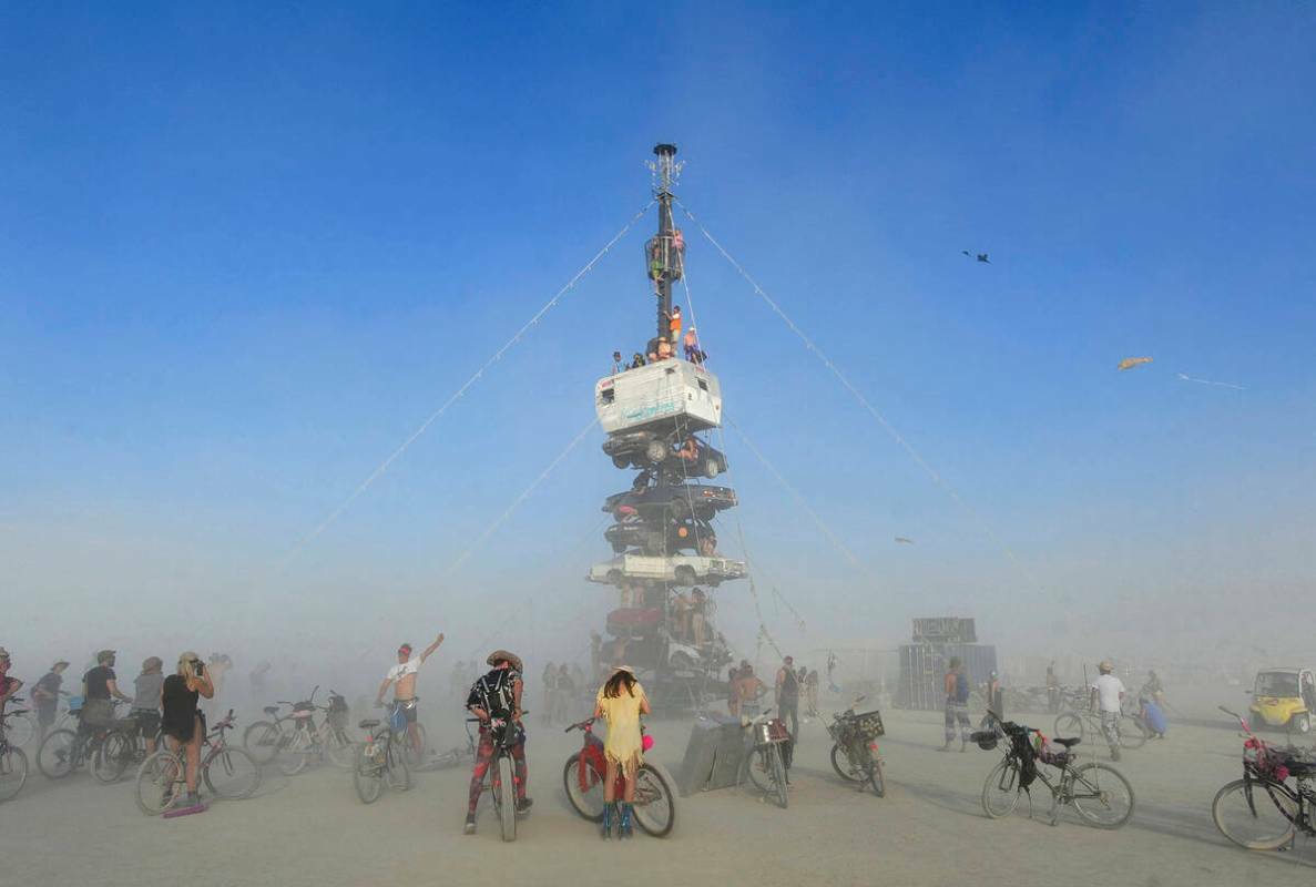 Asistentes trepan a una instalación de arte titulada ‘Night of the Climb’, en Burning Man, ...