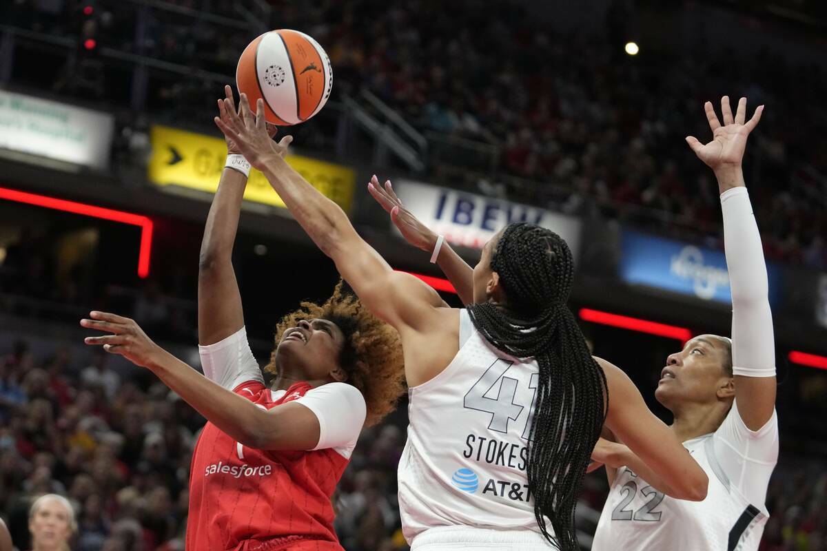 NaLyssa Smith (1) de Indiana Fever lanza por encima de Kiah Stokes y A'ja Wilson (22) de Las Ve ...