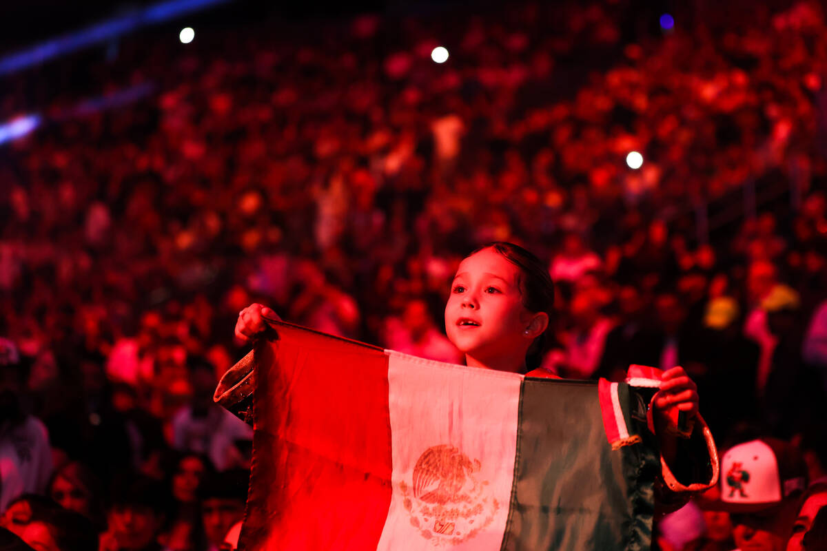 Un joven fanático de Canelo Álvarez sostiene la bandera mexicana antes de la pelea de boxeo p ...