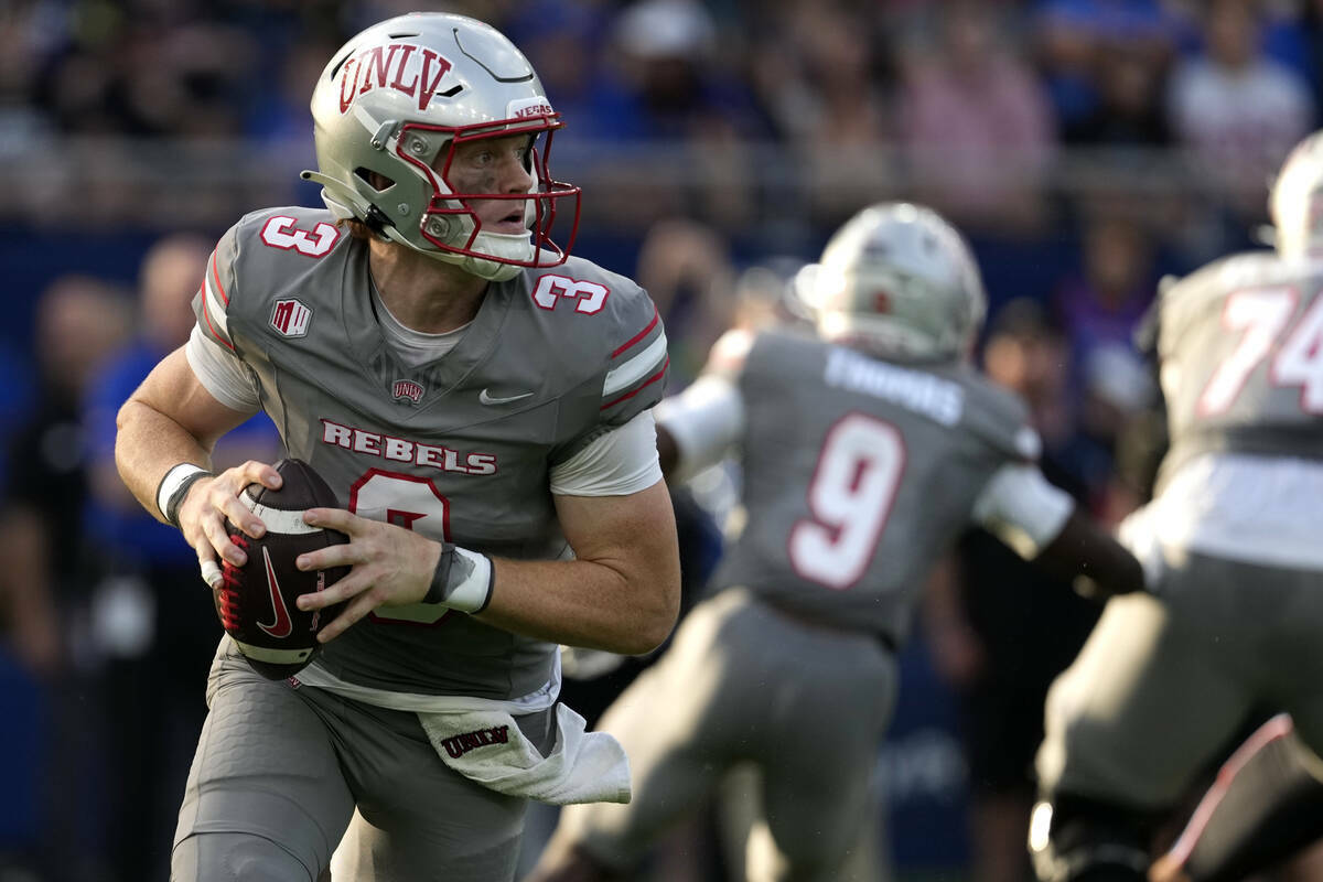 El quarterback de la UNLV Matthew Sluka (3) busca un pase contra Kansas en la primera mitad de ...