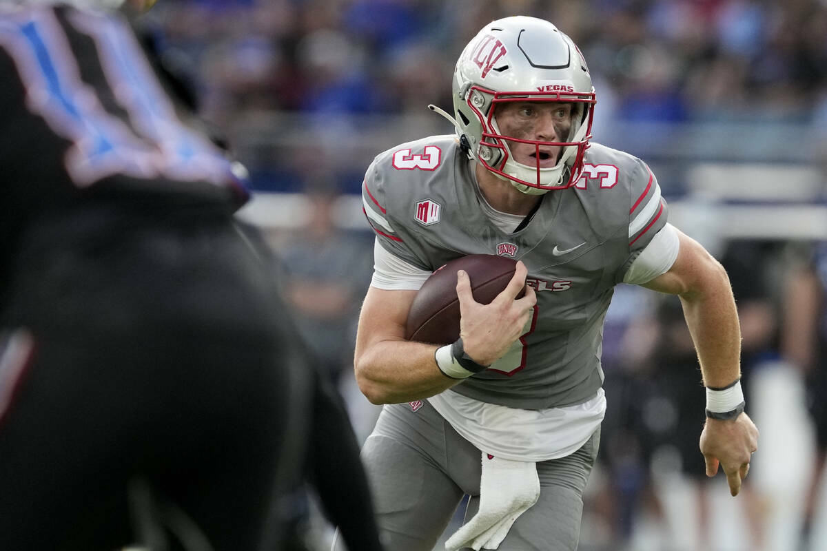 El quarterback de la UNLV Matthew Sluka corre con el balón en la primera mitad contra Kansas d ...