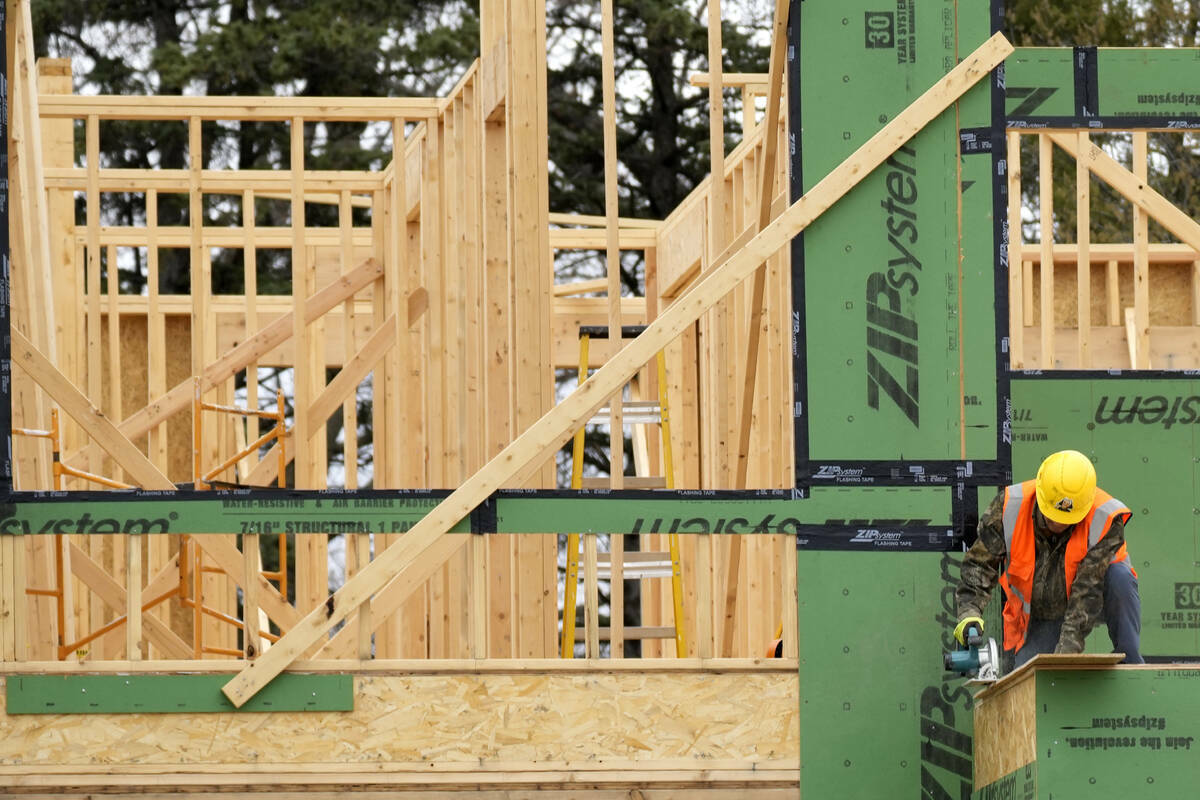 Un trabajador de la construcción corta madera en un sitio de construcción residencial en Moun ...