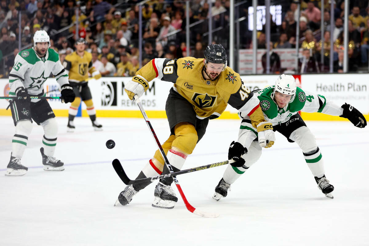 El centro de los Golden Knights Tomas Hertl (48) intenta escapar con el puck mientras el defens ...