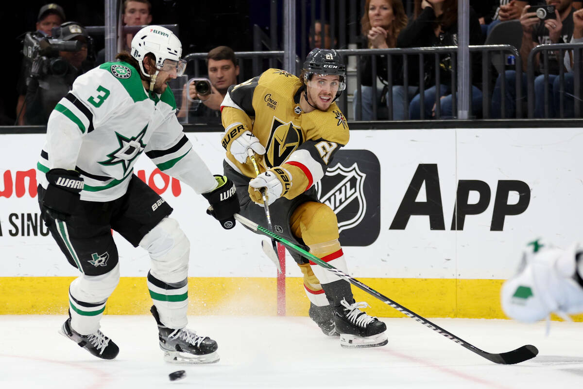 El centro de los Golden Knights Brett Howden (21) lanza un pase mientras el defensa de los Star ...