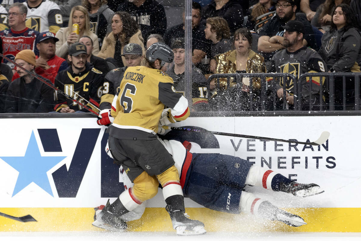 El defensa de los Golden Knights Kaedan Korczak (6) golpea al centro de los Capitals Dylan Stro ...