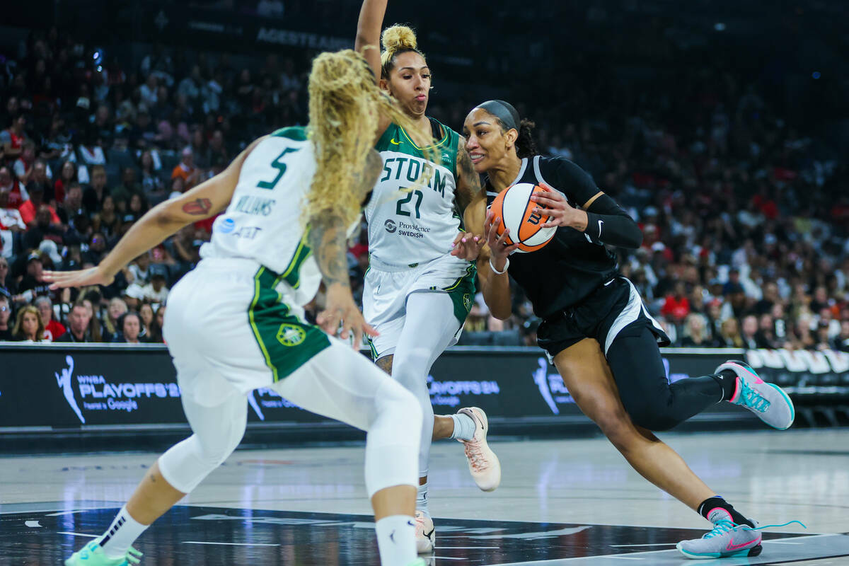 La centro de las Aces A'ja Wilson (22) conduce el balón a través de la centro de las Seattle ...