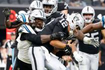 El quarterback de los Raiders Aidan O'Connell (12) es derribado por el linebacker de los Caroli ...