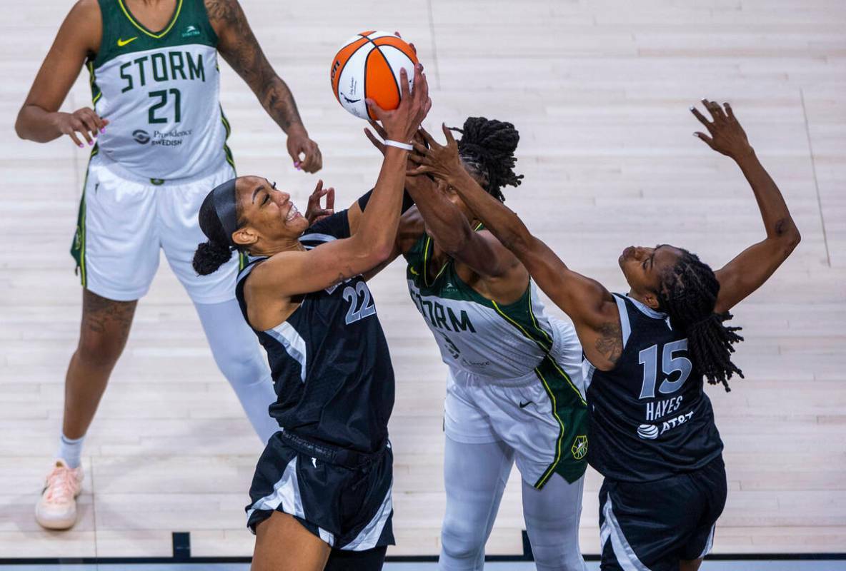 La centro de las Aces A'ja Wilson (22) toma un rebote sobre la alero de las Seattle Storm Nneka ...