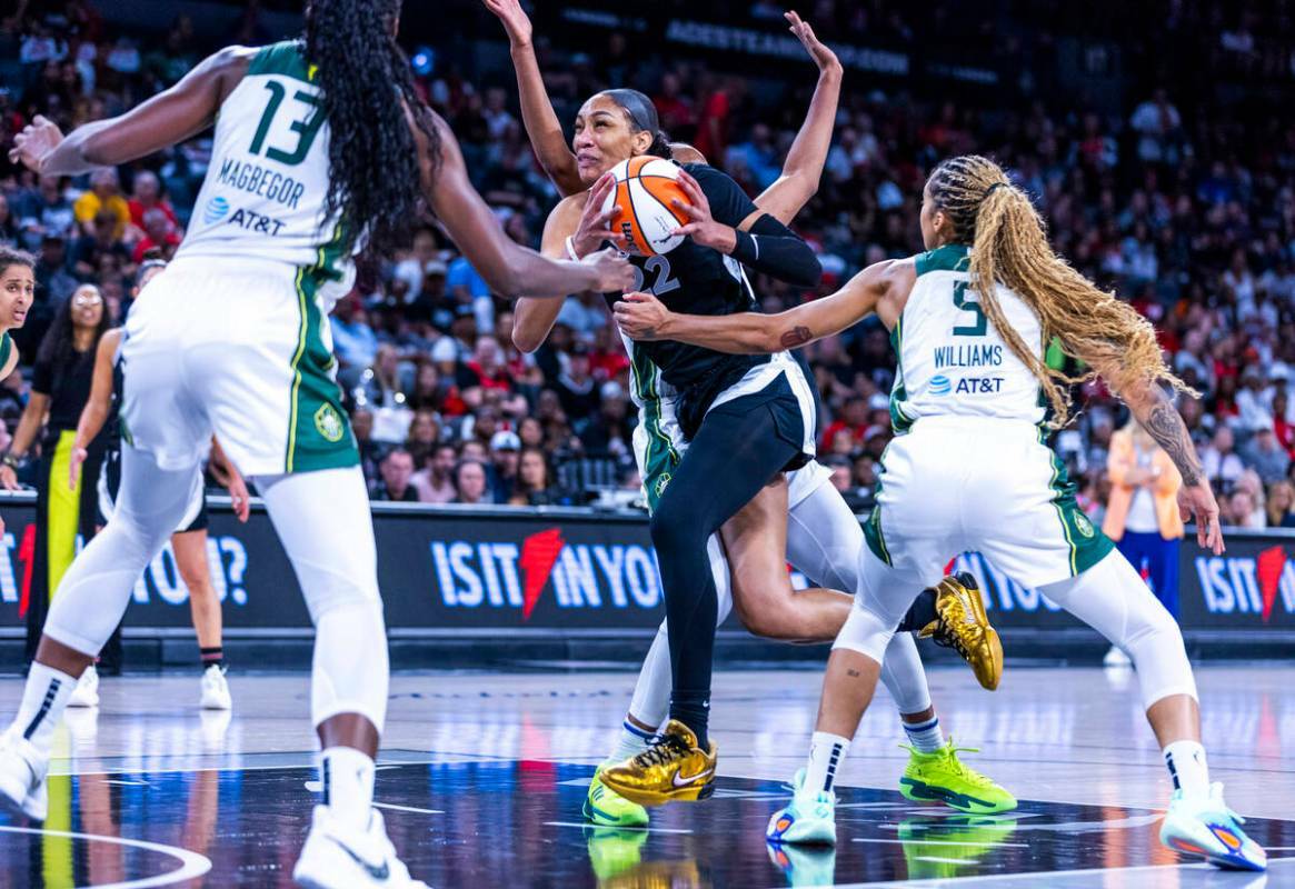 La centro de las Aces A'ja Wilson (22) avanza hacia la canasta contra la alero Gabby Williams ( ...