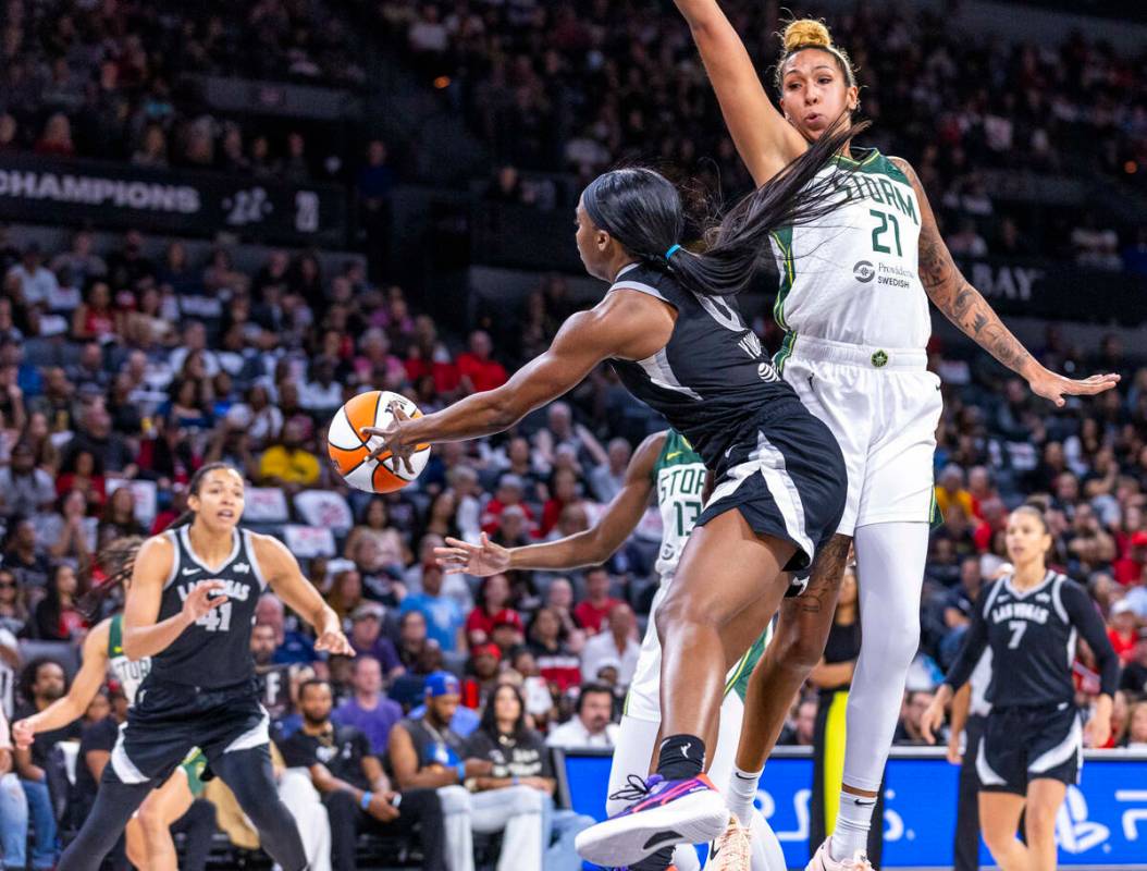 La escolta de las Aces Jackie Young (0) rodea a la centro de las Seattle Storm Mercedes Russell ...