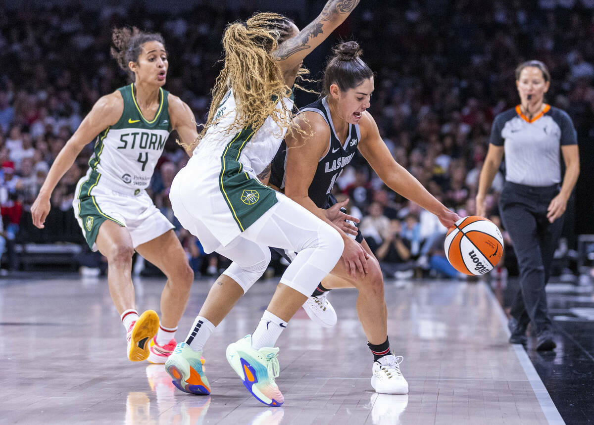 La escolta de las Aces Kelsey Plum (10) lucha contra un doble equipo formado por la alero Gabby ...