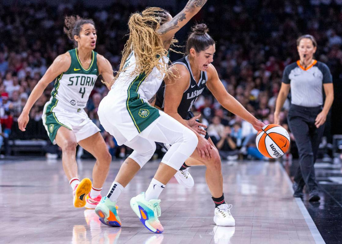 La escolta de las Aces Kelsey Plum (10) lucha contra un doble equipo formado por la alero Gabby ...