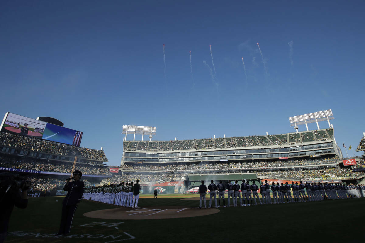 ARCHIVO - Fanáticos en el Oakland Coliseum escuchan mientras se presenta el himno nacional ant ...