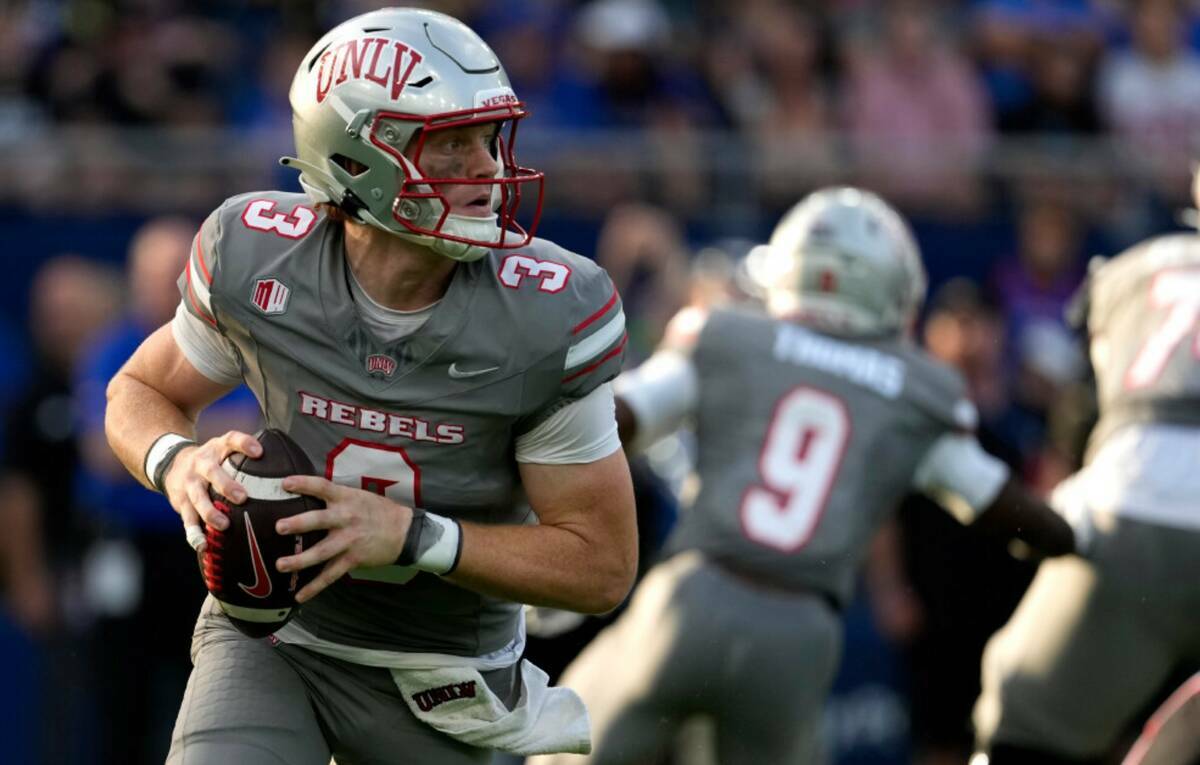 El quarterback de la UNLV Matthew Sluka (3) busca un pase contra Kansas en la primera mitad de ...