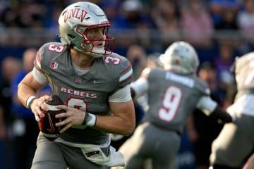 El quarterback de la UNLV Matthew Sluka (3) busca un pase contra Kansas en la primera mitad de ...