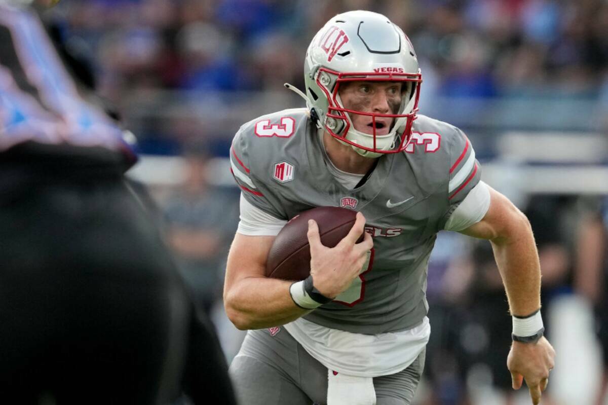 El quarterback de la UNLV Matthew Sluka corre con el balón en la primera mitad contra Kansas d ...